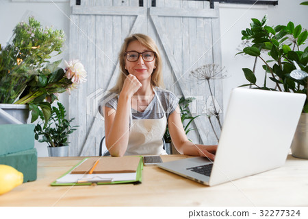Florist girl sitting at table Florist girl sitting at table 32277324