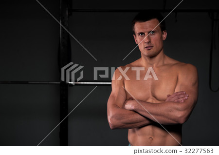 Muscular athletic man with naked torso in gym. 32277563