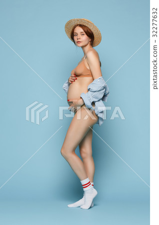 Young beautiful pregnant woman standing on blue Young beautiful pregnant woman standing on blue 32277632