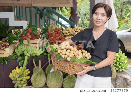 Asian woman with tropical fruit basket 32277879