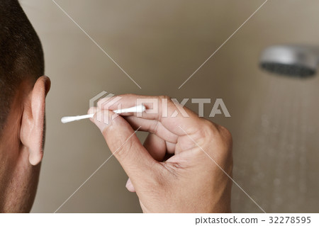 young man about to use a cotton swab 32278595