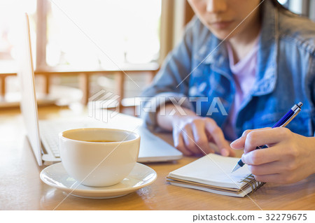 woman's hand using laptop and writing in notepad 32279675