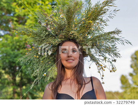 Beautiful girl in wreath of wild flowers portrait. 32279749