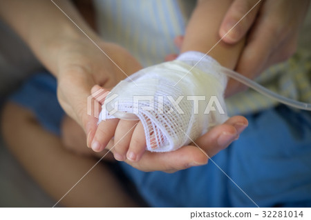 child's hand receiving iv saline solution 32281014