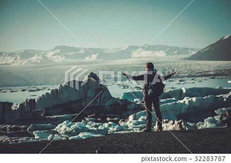 Woman explorer lookig at Jokulsarlon lagoon 32283787