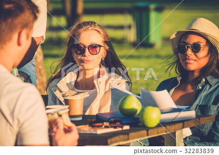 Multi-ethnic friends drinking coffee and chatting 32283839