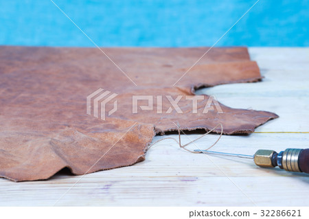 Leather craft tools on a wooden background 32286621