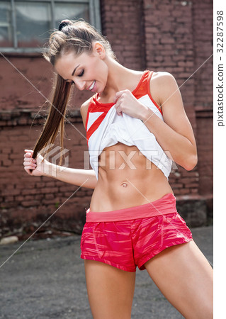 Side view of female athlete stretching leg 32287598