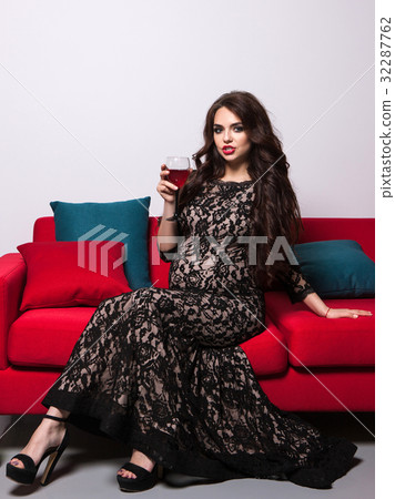 Pregnant woman with red wine on sofa Pregnant woman with red wine on sofa 32287762