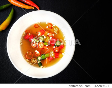 Fish sauce with chili on black background Fish sauce with chili on black background 32289625