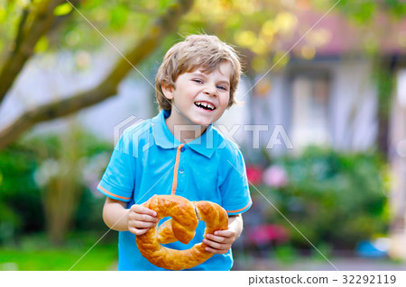 Adorable little kid boy eating huge big bavarian Adorable little kid boy eating huge big bavarian 32292119