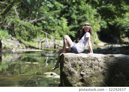 A beautiful woman relaxing by the river A beautiful woman relaxing by the river 32292637