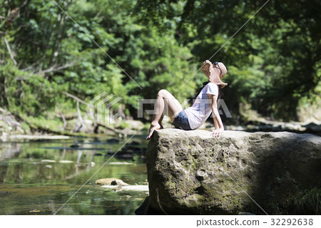 A beautiful woman relaxing by the river A beautiful woman relaxing by the river 32292638