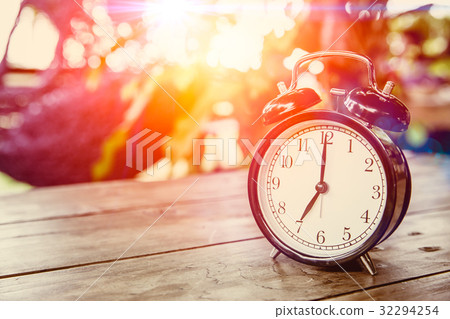 clock on wood table with sunlight  clock on wood table with sunlight  32294254