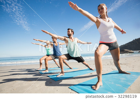 People doing yoga on the beach 32298119