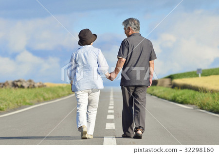 走在一條唯一街道的資深夫婦握手 走在一條唯一街道的資深夫婦握手 32298160