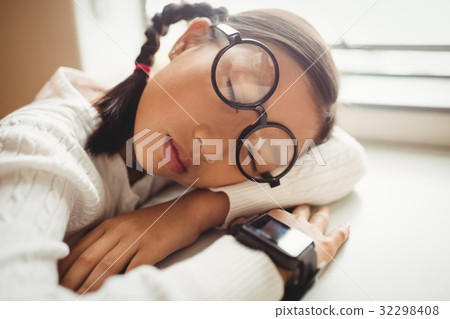 Schoolchild sleeping on desk 32298408