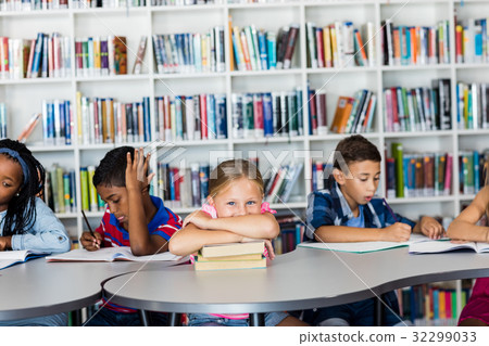 Little girl posing arm crossed at desk 32299033