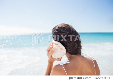 Portrait of smiling woman listening shellfish 32299184