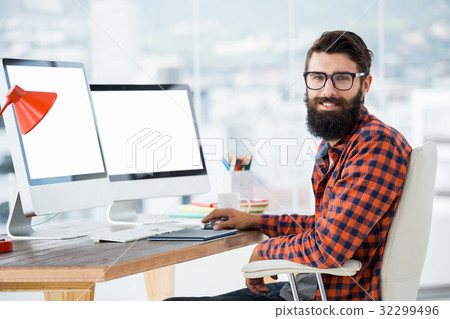 Hipster sitting in front of a computer 32299496