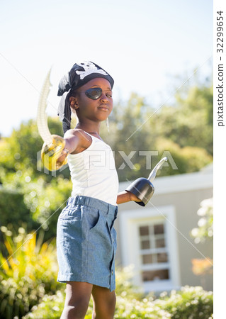 Cute mixed-race girl wearing pirate clothes and pointing the camera with plastic sword 32299654