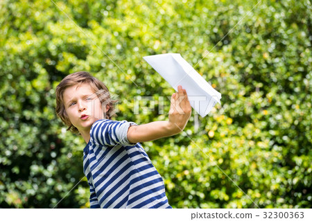 Portrait of cute boy playing with a paper plane 32300363
