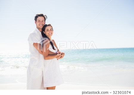 Happy couple embracing on the beach Happy couple embracing on the beach 32301074