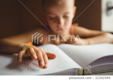 Little girl using his right hand to read braille Little girl using his right hand to read braille 32302949