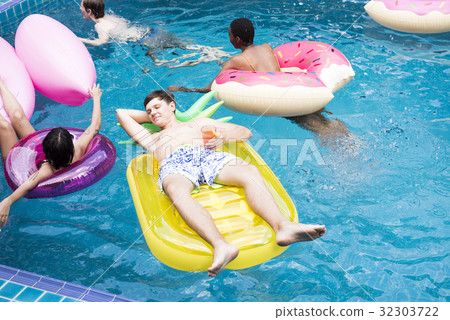 Group of diverse friends enjoying the pool with inflatable tubes Group of diverse friends enjoying the pool with inflatable tubes 32303722