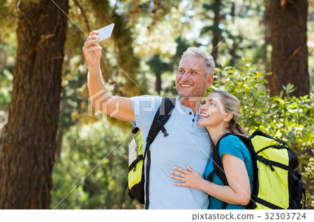 Couple smiling and taking a photo Couple smiling and taking a photo 32303724