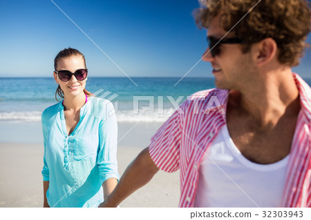 Happy couple posing on the beach Happy couple posing on the beach 32303943