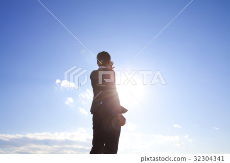 A businessman holding his hand over the sun 32304341