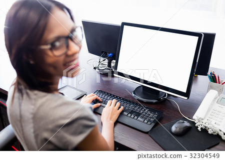 Casual businesswoman working on laptop Casual businesswoman working on laptop 32304549