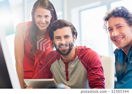 Smiling colleagues using a tablet 32305344