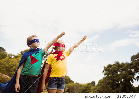 Children with superhero dress posing with raised arm Children with superhero dress posing with raised arm 32305347