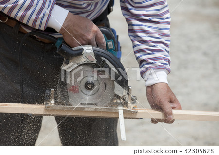 Carpenter using a motorized saw 32305628