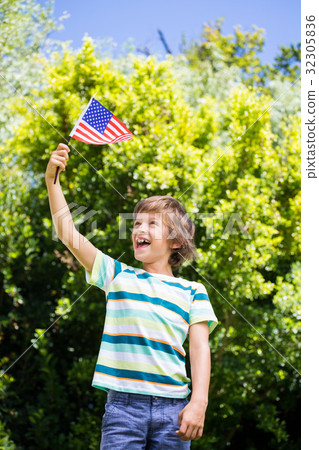 A little boy is holding an american flag 32305836
