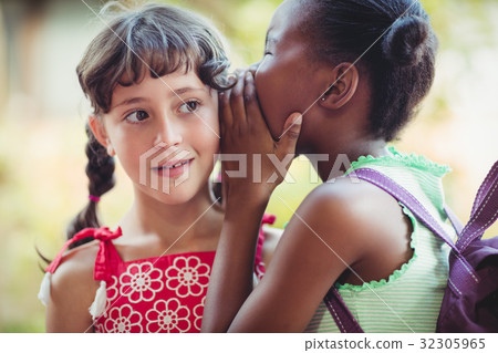 Girl telling a secret to her friend Girl telling a secret to her friend 32305965