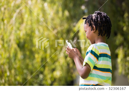 A kid playing with a mobile phone 32306167