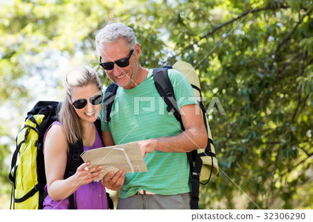 Couple smiling and looking a map Couple smiling and looking a map 32306290
