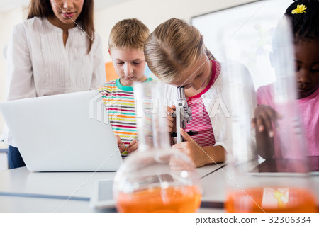 Pupil looking through a microscope 32306334
