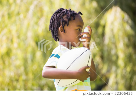 Child is using an asthma inhaler 32306435