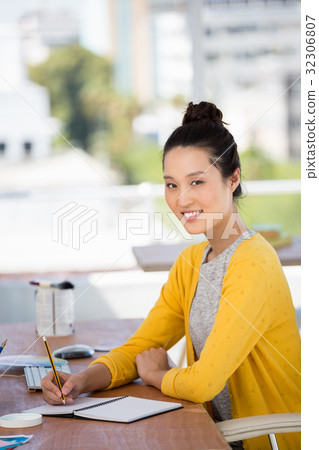 a businesswoman is sitting at her desk 32306807