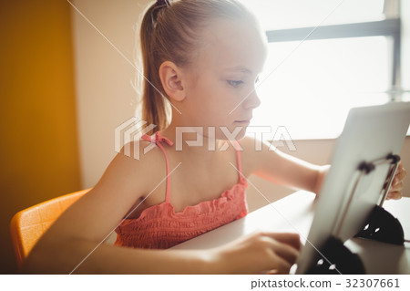 Seated girl using digital tablet Seated girl using digital tablet 32307661