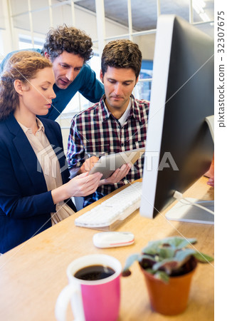 Businesspeople working and holding a tablet Businesspeople working and holding a tablet 32307675