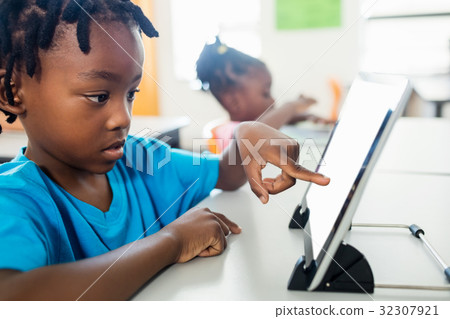 Side view of pupil using tablet pc in classroom Side view of pupil using tablet pc in classroom 32307921