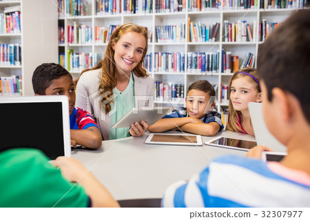 Young pretty teacher having lesson to children with their tablet Young pretty teacher having lesson to children with their tablet 32307977