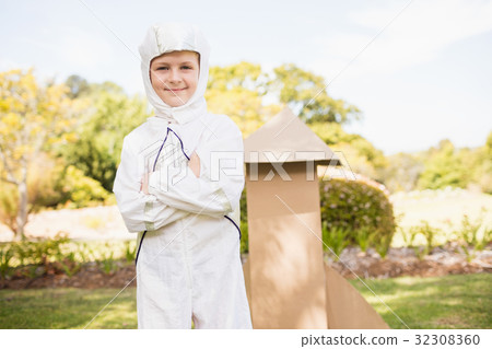 Portrait of cute boy with astronaut dress posing next to a rocket Portrait of cute boy with astronaut dress posing next to a rocket 32308360
