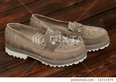Beige leather female boots on wooden background Beige leather female boots on wooden background 32311974