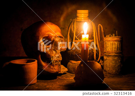 Skull and candle with candlestick on wooden  32313416